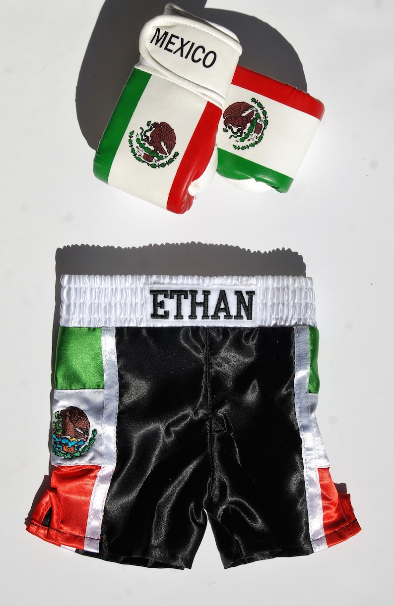 May include: Black satin boxing shorts with green, white, and red trim. The shorts have the Mexican flag on the side and the name "ETHAN" embroidered on the waistband.