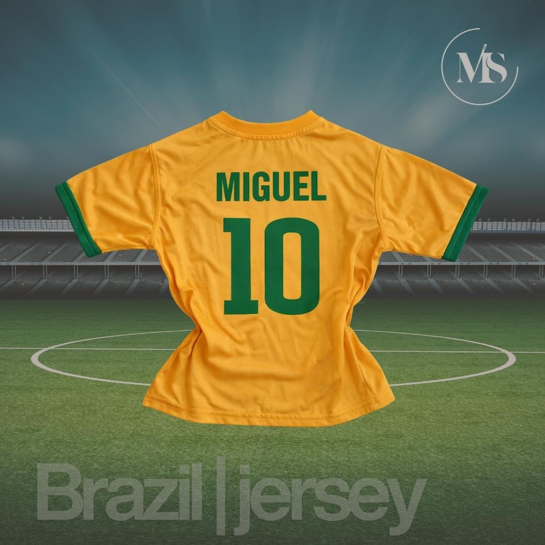 May include: A yellow Brazil jersey with green trim, featuring the name "MIGUEL" and the number "10" in green. The jersey is displayed on a green field with the words "Brazil jersey" at the bottom.