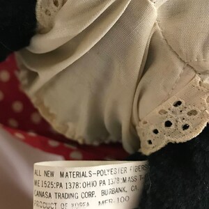 K&ouml;nnte beinhalten: Ein wei&szlig;es Etikett mit schwarzem Text, der "ALL NEW MATERIALS-POLYESTER FIBERS ME 1525:PA 1378: OHIO PA 1378:MASS T- CANASA TRADING CORP. BURBANK, CA. PRODUCT OF KOREA MER. 100" lautet.