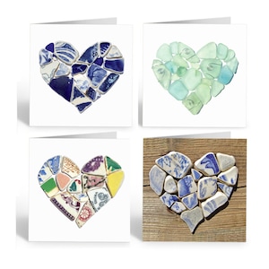 May include: Set of four greeting cards featuring heart-shaped designs made from broken pieces of sea glass and china. The cards are blank inside for writing a message.