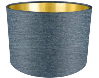 May include: A blue lampshade with a gold top. The lampshade is made of a textured fabric.