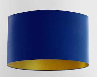 May include: A blue and gold drum lampshade. The top of the lampshade is a deep blue color, and the bottom is gold.