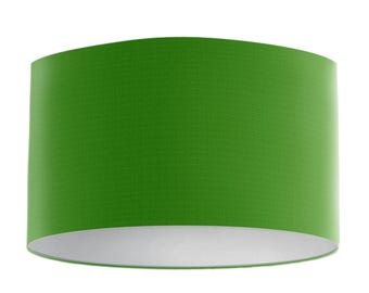 May include: A cylindrical lampshade in a vibrant green hue. The lampshade has a textured surface and a white interior. The design is simple and modern, suitable for various home decor styles. The lampshade is a lighting accessory.