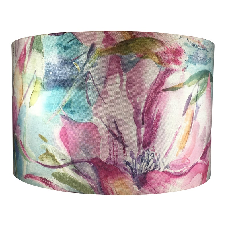 May include: A cylindrical lampshade with a floral print. The print features large pink, purple, and blue flowers on a white background.