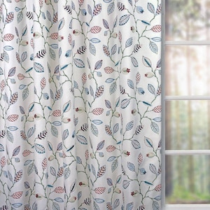 May include: White fabric with a repeating pattern of blue, green, and red leaves on a white background. The leaves are stylised and have a whimsical design.