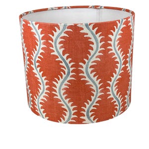 May include: A red and blue patterned lampshade with a white lining. The pattern features a repeating wave design with a blue outline.