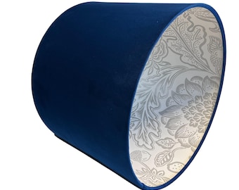May include: A blue velvet lampshade with a white floral pattern on the inside.