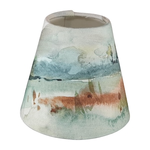 Peut inclure: Un abat-jour avec un motif de style aquarelle dans des tons de bleu, vert et orange. Le motif ressemble à un paysage avec des montagnes et de l'eau.
