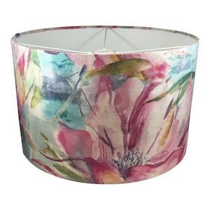 May include: A round lampshade with a floral print in shades of pink, blue, green, and yellow. The print resembles watercolor paintings of flowers.