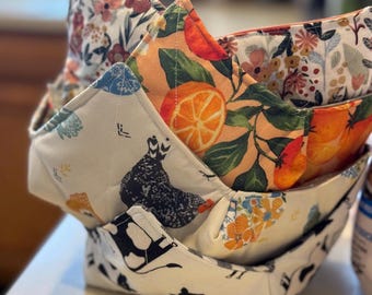 May include: Three fabric bowl covers, one with a chicken and farm animal print, one with a citrus fruit print, and one with a floral print.