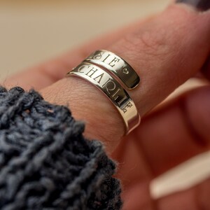 May include: A silver ring engraved with the names "Charlie" and "Ellie".