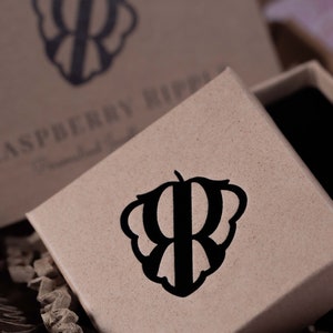 May include: A brown cardboard box with a black logo of a stylized raspberry with the letter "R" inside. The text "Raspberry Ripple" is printed on the box.