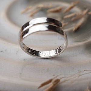 May include: A silver ring with a twisted band and the inscription "Love You Best" engraved on the inside.