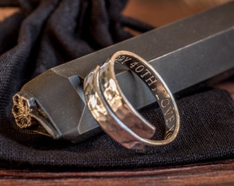 May include: A silver hammered ring with the inscription "Happy 40th Love You" on the band.