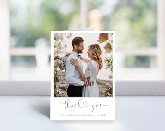 May include: A wedding thank you card with a photo of a couple in front of a floral arch. The card has the text "thank you" with a heart symbol and the couple's names and wedding date.