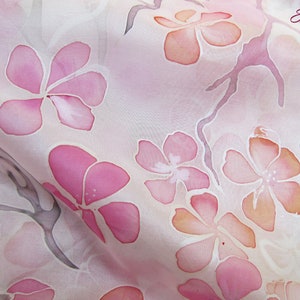 May include: A pink silk scarf with a delicate floral pattern of pink and orange flowers. The flowers are painted in a watercolor style and have a soft, ethereal look. The scarf is made of a lightweight, flowing fabric that is perfect for spring and summer.