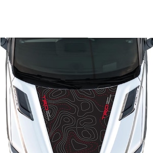 May include: A white truck hood with a black and red "TRD Off Road" decal. The decal features a topographic map design with red dashed lines.