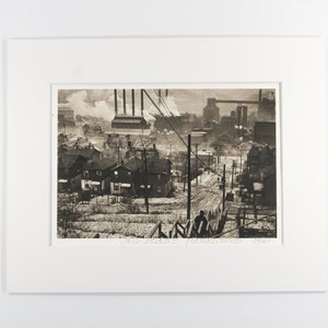 May include: A black and white photograph of a residential street in a city with industrial buildings in the background. The street is lined with houses and there are power lines running overhead. The photo is signed "Carl  Zang  Bradford  2002".