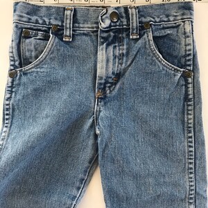 May include: A pair of light blue denim jeans with a button fly and five pockets. The jeans have a faded look and are made of a soft, comfortable fabric.