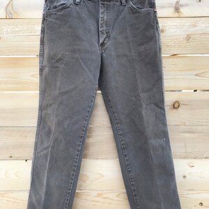 May include: A pair of dark gray denim jeans with a button fly and belt loops.