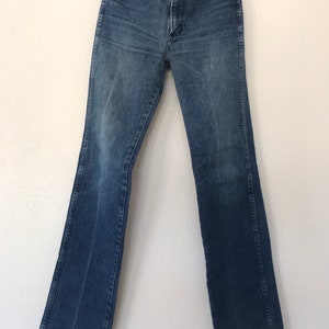 May include: A pair of blue denim jeans with a straight leg fit. The jeans have a button fly and belt loops.