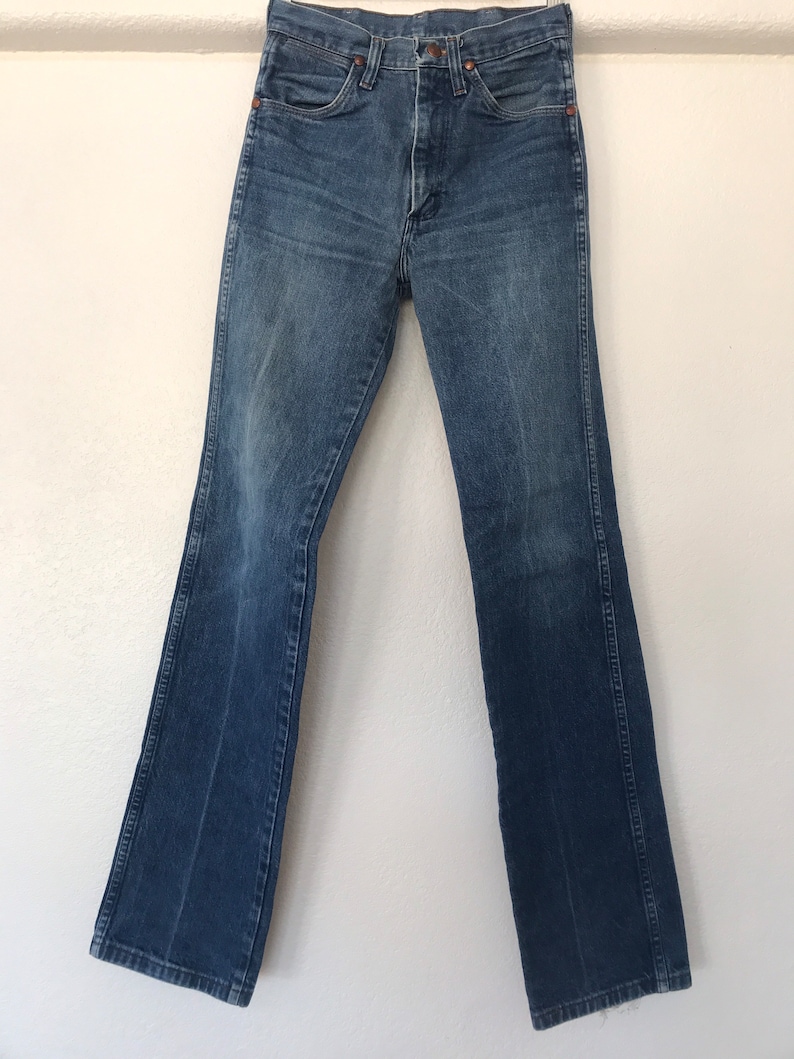 May include: A pair of blue denim jeans with a straight leg fit. The jeans have a button fly and belt loops.