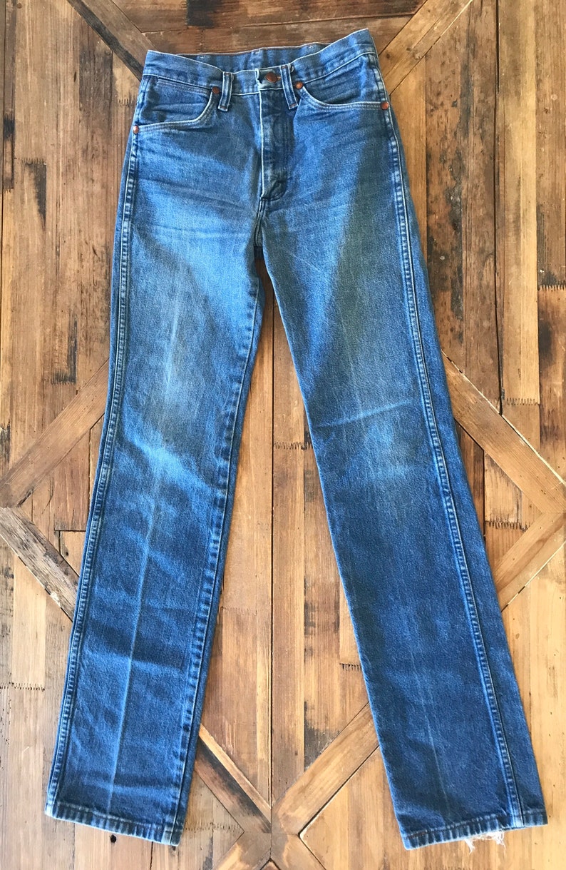 May include: A pair of blue denim jeans with a straight leg fit. The jeans have a button fly and belt loops.