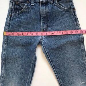May include: A pair of blue denim shorts with a frayed hem. The shorts have a light wash and are made of a soft, comfortable fabric. The shorts measure 16 inches in length.