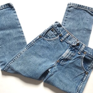 May include: A pair of light blue denim jeans with a button fly and five pockets.