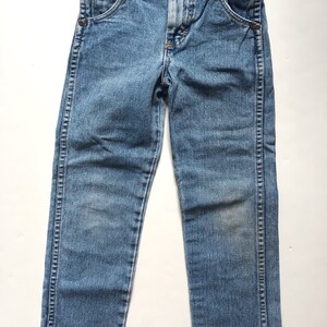 May include: A pair of light blue denim jeans with a straight leg fit. The jeans have a button fly and belt loops.