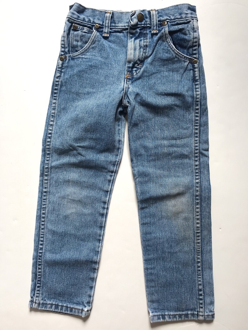 May include: A pair of light blue denim jeans with a straight leg fit. The jeans have a button fly and belt loops.