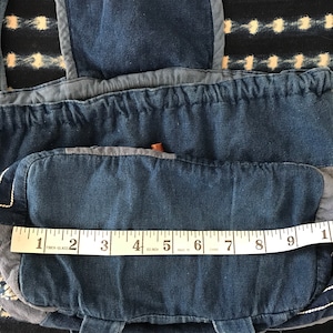 Puede incluir: Una bolsa de lona azul de mezclilla con una solapa y un cierre de cord&oacute;n. La bolsa est&aacute; hecha de diferentes tonos de mezclilla azul y tiene una cinta m&eacute;trica blanca en la parte inferior. La cinta dice "1 2 FIBER-GLASS 3 4 60 INCH 5 MADE IN 6 CHNA 7 8 9 1".