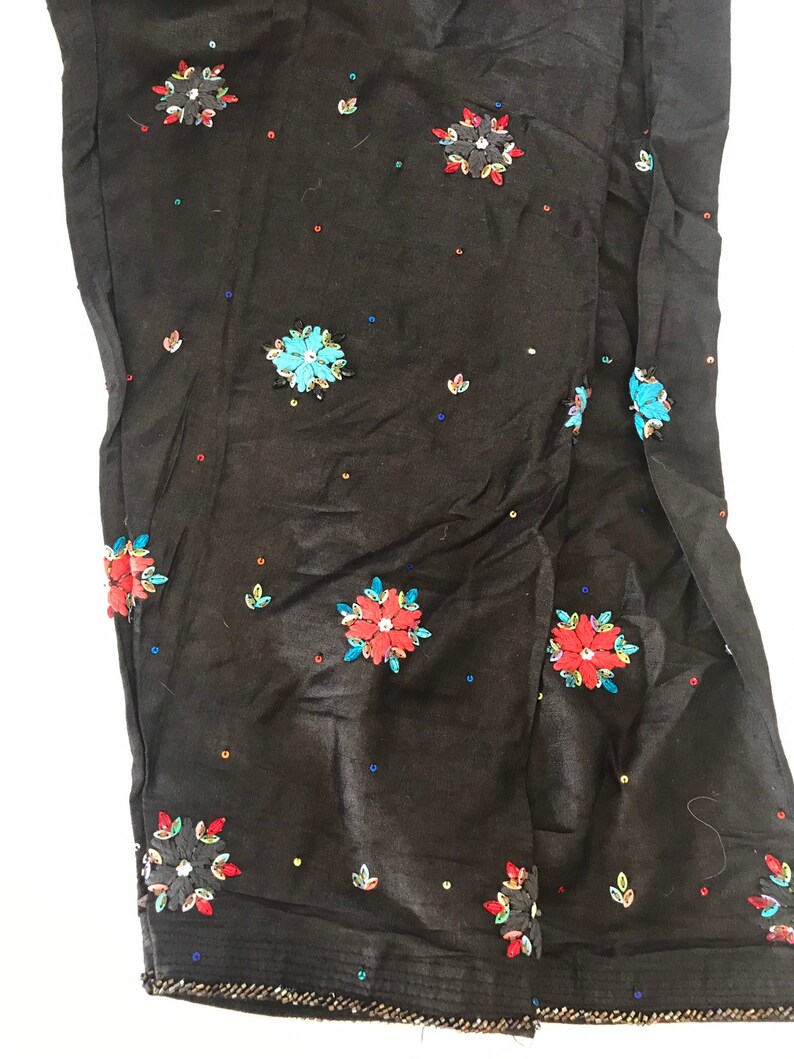May include: Black pants with colorful embroidered flowers and sequins.