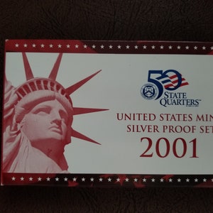 May include: A United States Mint Silver Proof Set from 2001. The box features the Statue of Liberty in red and white, with the text "50 State Quarters" and "Silver Proof Set".