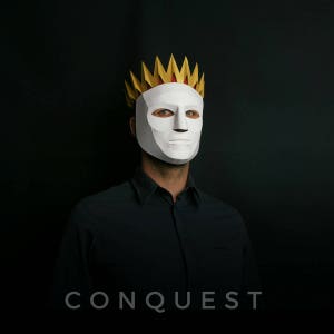May include: A person wearing a white mask with a gold and red crown. The mask has a serious expression. The background is black. The text "CONQUEST" is printed below the image.