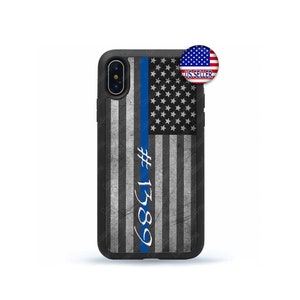 May include: Black iPhone case with a distressed American flag design and a blue line down the center. The text '#1589' is written in white on the case.