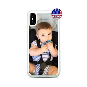 May include: White iPhone case with a photo of a baby in a stroller. The baby is wearing a striped onesie and has a pacifier in their mouth. The case has a clear back and a white frame.