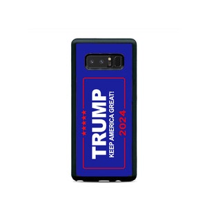 May include: A blue phone case with a black border. The case has a white rectangle with the text "TRUMP" in large white letters and "KEEP AMERICA GREAT!" in smaller white letters. Below the text is a red rectangle with five red stars and the text "2024" in red letters.