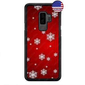 May include: A black phone case featuring a red gradient design adorned with white snowflake patterns. The case has a black frame and a camera aperture. A sticker in the top right corner reads "US SELLER".