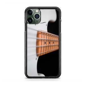 Könnte beinhalten: Eine weiße E-Bassgitarre mit einem braunen Holzgriffbrett. Die Gitarre ist scharf gestellt, der Hintergrund ist verschwommen.