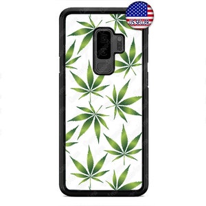 May include: A black phone case with a white background and a green marijuana leaf pattern. The case has a cutout for the camera lens.