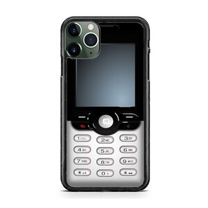 Puede incluir: Una funda de teléfono negra y plateada con un diseño de teclado retro. La funda tiene un borde negro y un teclado plateado con botones numéricos blancos. Las lentes de la cámara del teléfono son visibles en la parte superior.