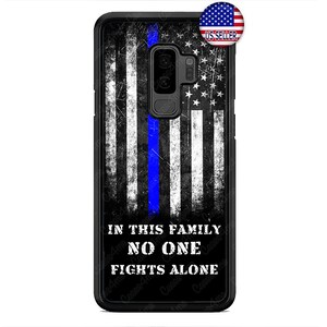 May include: Black phone case with a distressed American flag design and a thin blue line down the center. The text "In this family no one fights alone" is printed on the bottom of the case.