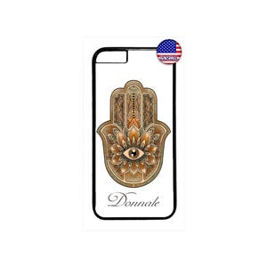 Könnte beinhalten: Eine transparente Handyhülle mit schwarzem Rand. Die Hülle zeigt eine goldene und braune Hamsa-Hand mit einem Auge in der Mitte. Das Wort "Donnale" ist in Schwarz am unteren Rand der Hülle aufgedruckt.