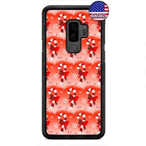 Pode incluir: Uma capa de telefone preta com um padrão de bengalas de doces vermelhas e brancas. A capa tem um recorte para a lente da câmera e uma borda elevada ao redor das bordas para proteger a tela.