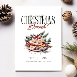 May include: A white invitation card with the text "YOU'RE INVITED TO OUR CHRISTMAS Brunch!" in green and red. The card features a watercolor illustration of pancakes with berries and greenery. The date and time are also included.