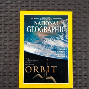 May include: A November 1996 National Geographic magazine, Volume 190, Number 5, featuring a yellow border and a cover image of Earth from space. The text reads: The Astronauts' View of Home, Orbit, and a list of articles including Sir Joseph Banks.