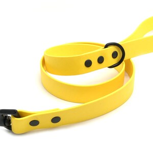May include: A bright yellow dog leash with a black metal clip and three black accents. The leash is made of a durable rubber material.