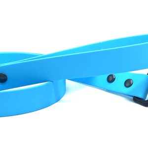 May include: A bright blue dog leash with a black metal clip and three black metal accents. The leash is made of a durable rubber material.
