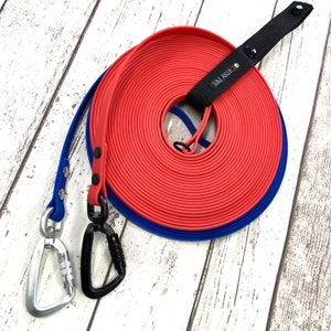 May include: A red and blue dog lead with a black handle. The handle has the text "Ducky Pet" printed on it.